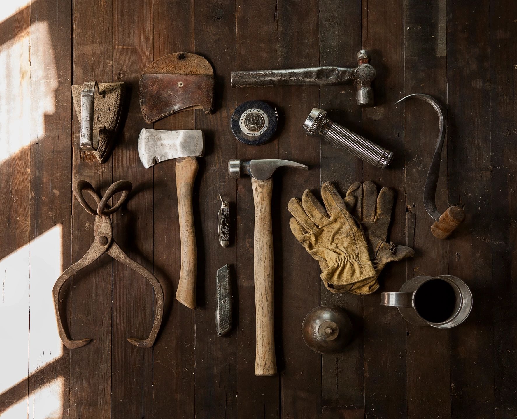 Vintage construction hand tools arranged on dark wooden planks