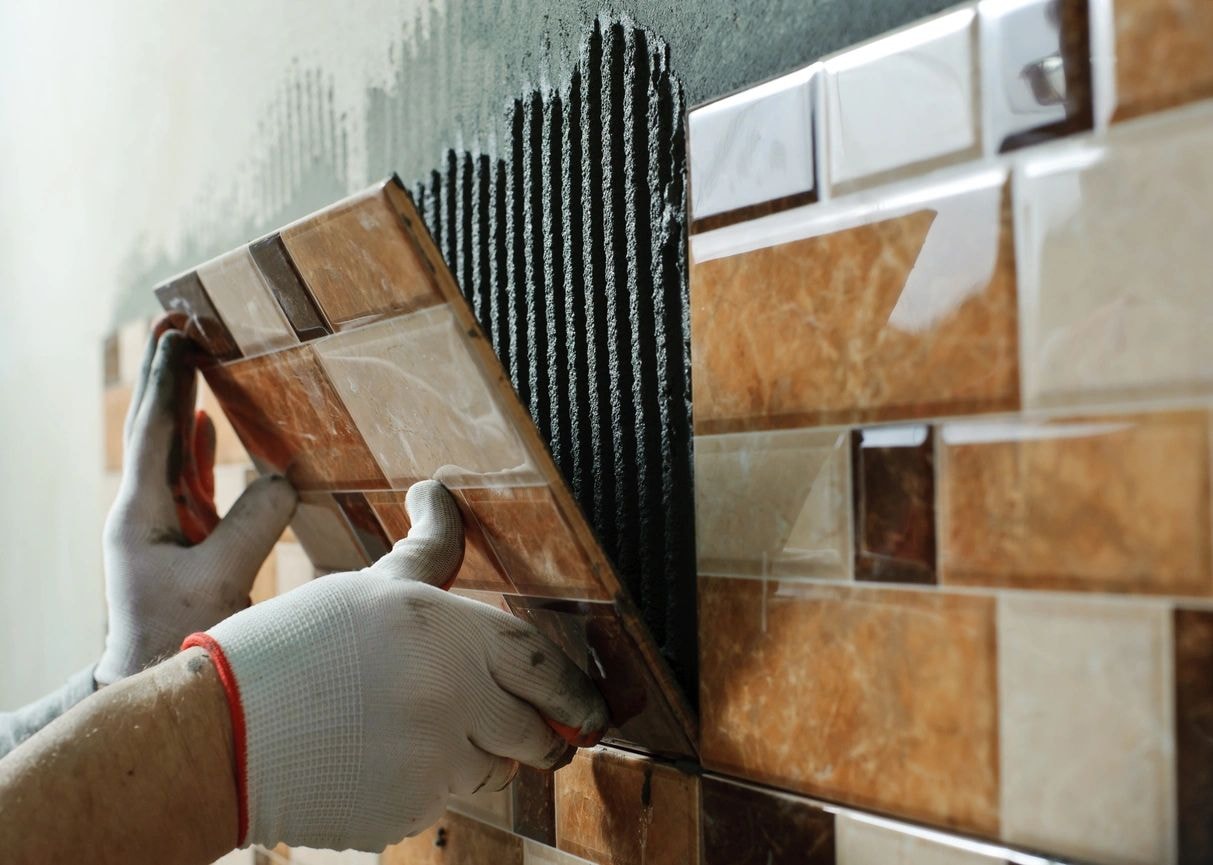 Worker installing patterned ceramic wall tile